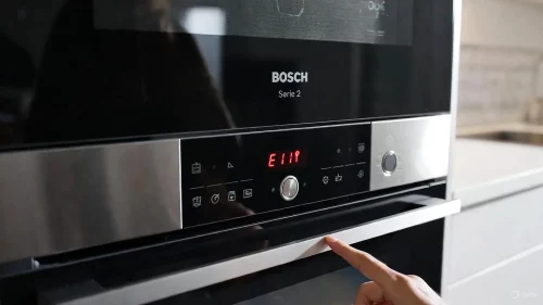 Das Display eines Bosch Backofens zeigt den Fehler E11 und das Kindersicherungs-Symbol in Deutsch.