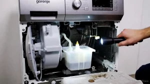 Reinigung des Pumpenfilters bei Gorenje Waschmaschine Fehler 7, Münze als Ursache gefunden.