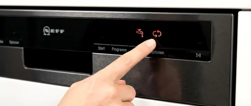 Nahaufnahme der Bedienblende einer Neff Spülmaschine mit leuchtenden roten Symbolen für Wasserhahn und Salz.